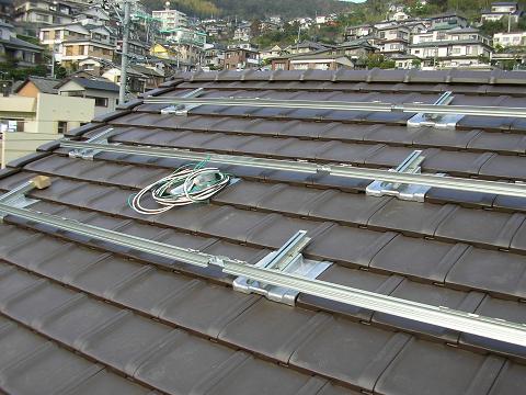 屋根瓦にパネルを取り付ける際の金物です。強固に固定されています。