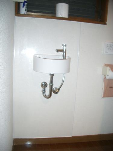 丸い形がかわいい手洗い器に変更しました。壁は水や汚れに強いパネルを使っています。