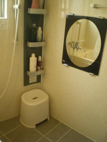 スライド式のシャワーフック・鏡・収納棚・照明はダウンライト。最初のご希望のユニットバスに近づけました。