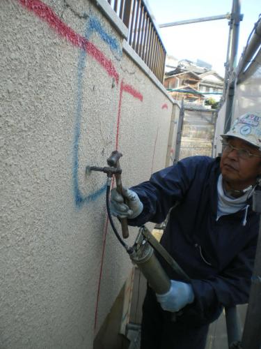 モルタルの浮きが著しい部分に専用ボンドを注入しています。