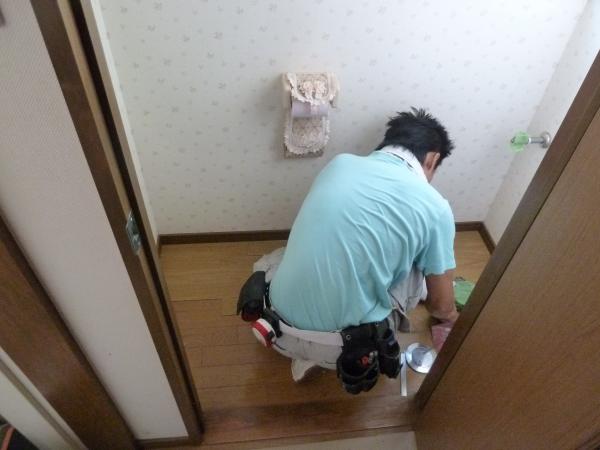 内装の職人が床にフロアタイルを重ね貼り中です。